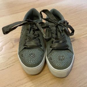 These are army green sneakers with sequence and ribbon laces.